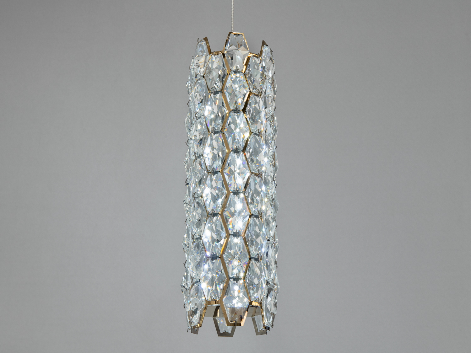 Підвісний світильник циліндричної форми з кришталевими елементами, що відбивають світло, підходить для сучасного інтер′єру.