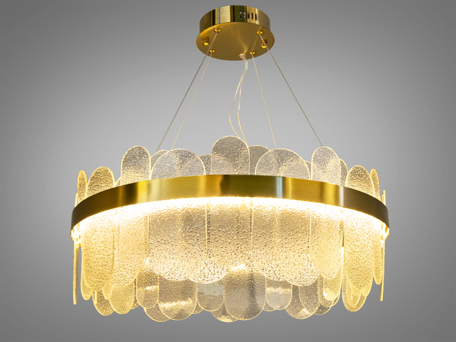 Підвісна люстра з прозорими скляними елементами та золотистим обідком, створює м′яке освітлення, підходить для сучасного інтер′єру.