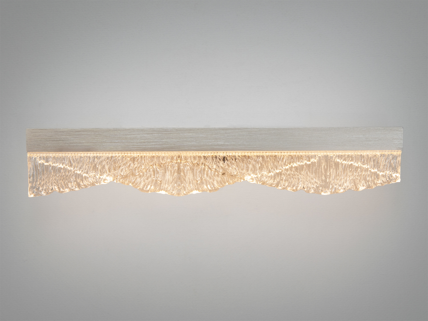 Світильник з теплим жовтим світлом, виготовлений з прозорого скла, має хвилястий край, монтується на стіну.