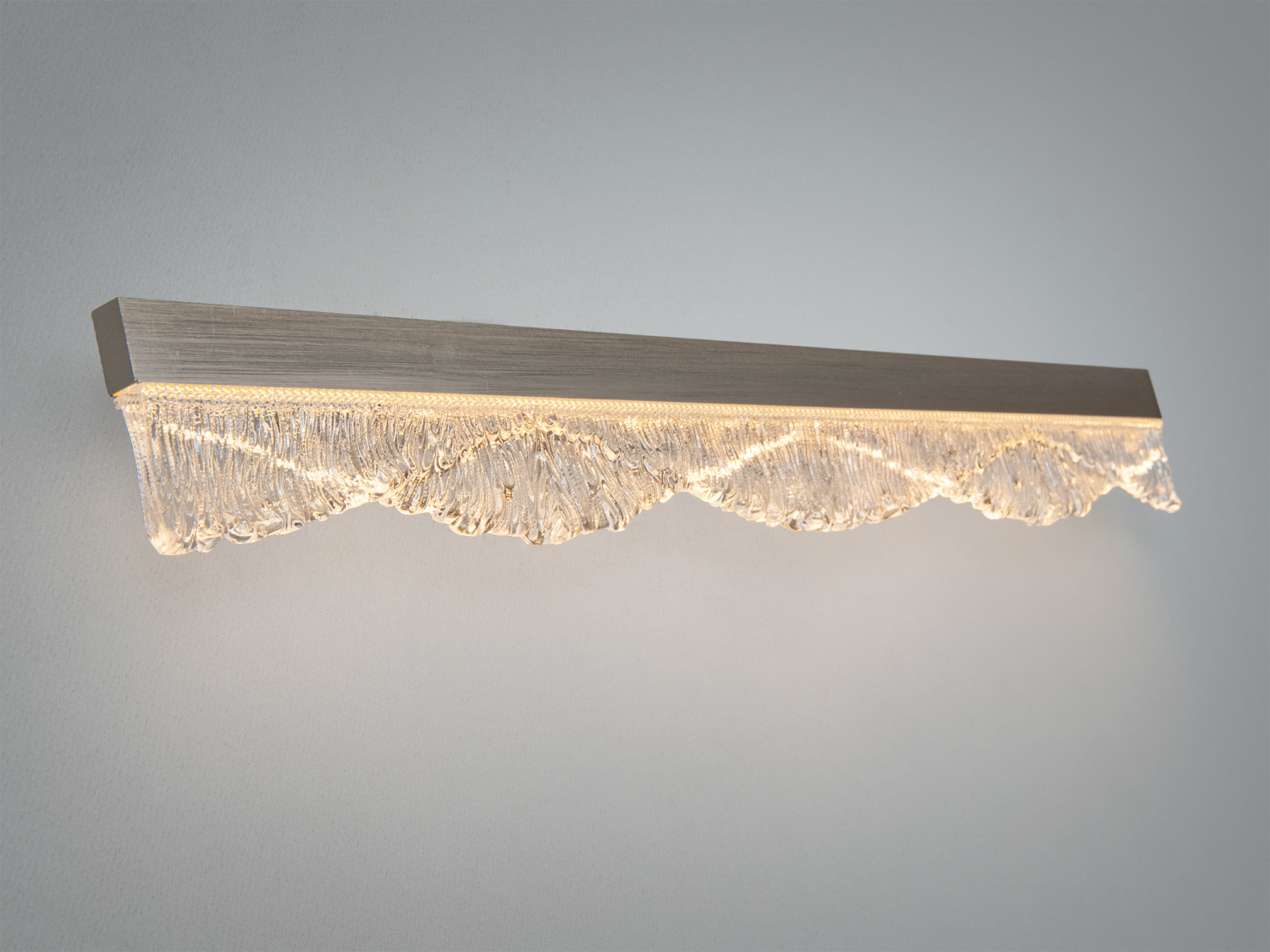 Настінний світильник з LED підсвіткою, виготовлений з матового металу і скла. Використовується для акцентного освітлення в житлових приміщеннях.