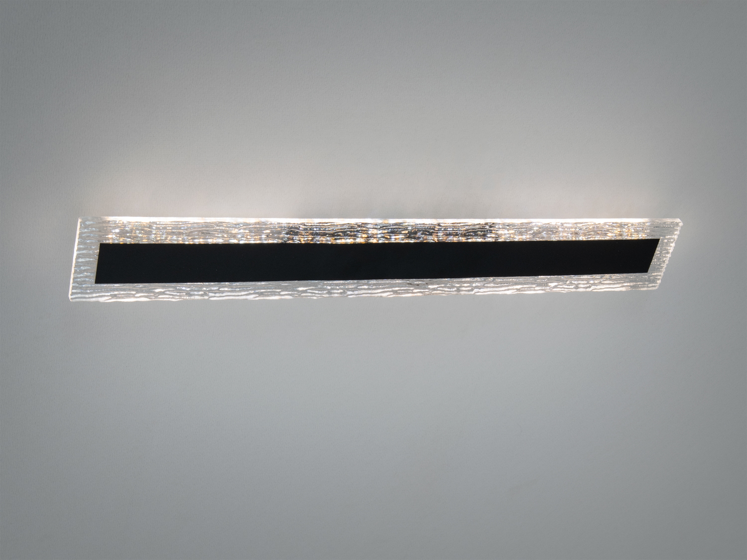 Настінний світильник з текстурованого скла з чорним матовим елементом. Ідеальний для освітлення вітальні або офісу.