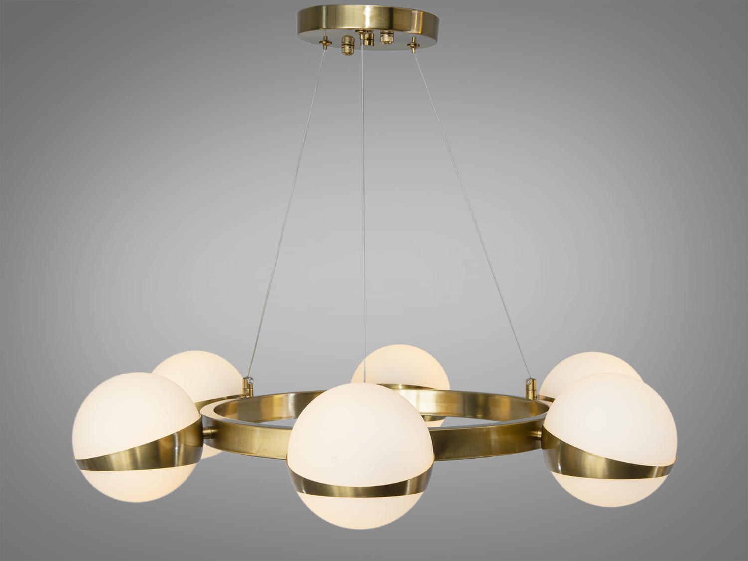 Металеве кільце люстри в кольорі бронзи, яке висить на напівпрозорих підвісах, створює враження легкості та елегантності. 