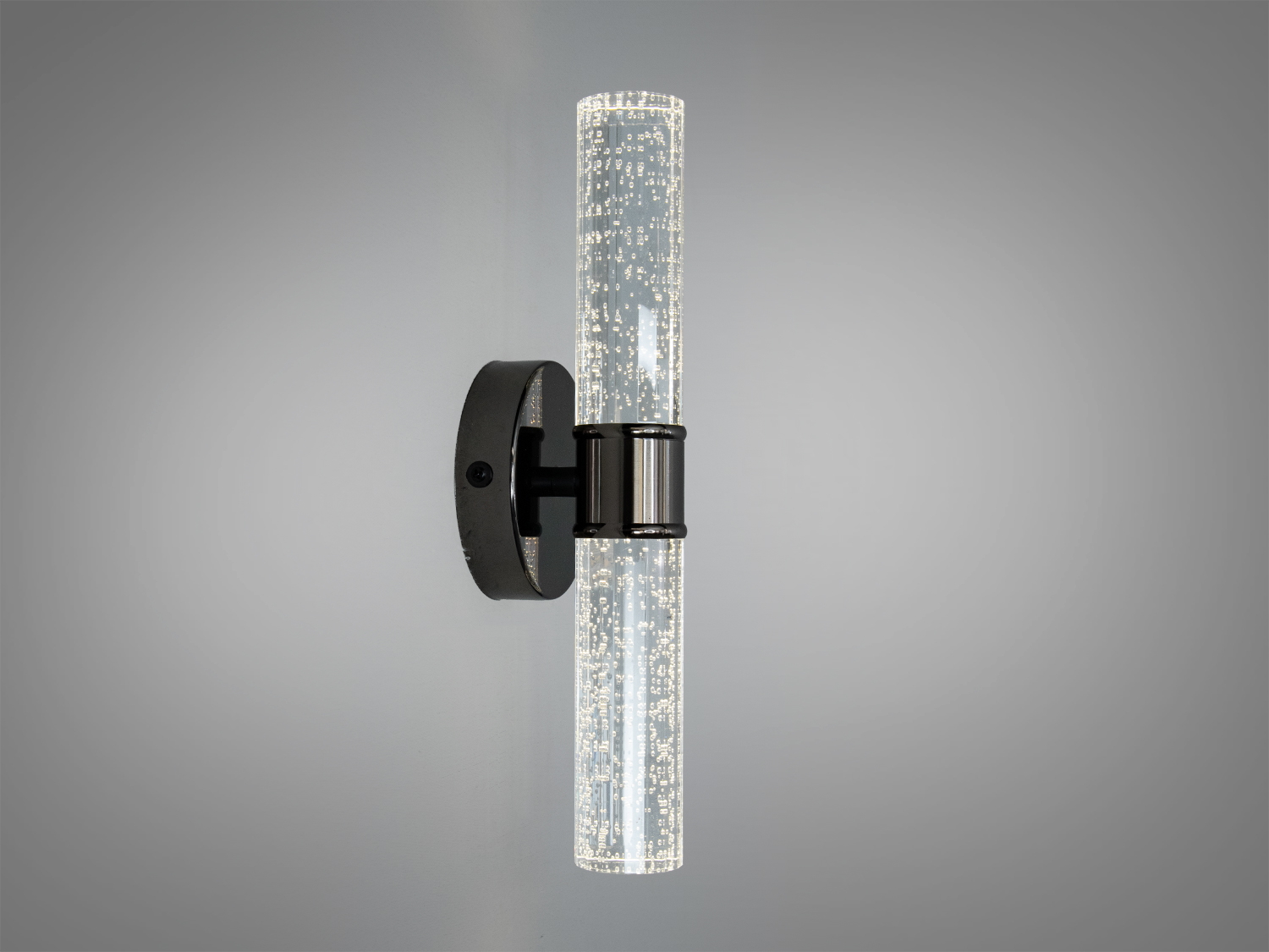 Світильник з прозорим циліндричним плафоном, прикрашеним бульбашками. Металева основа підходить для ванної кімнати. Вертикальний монтаж.