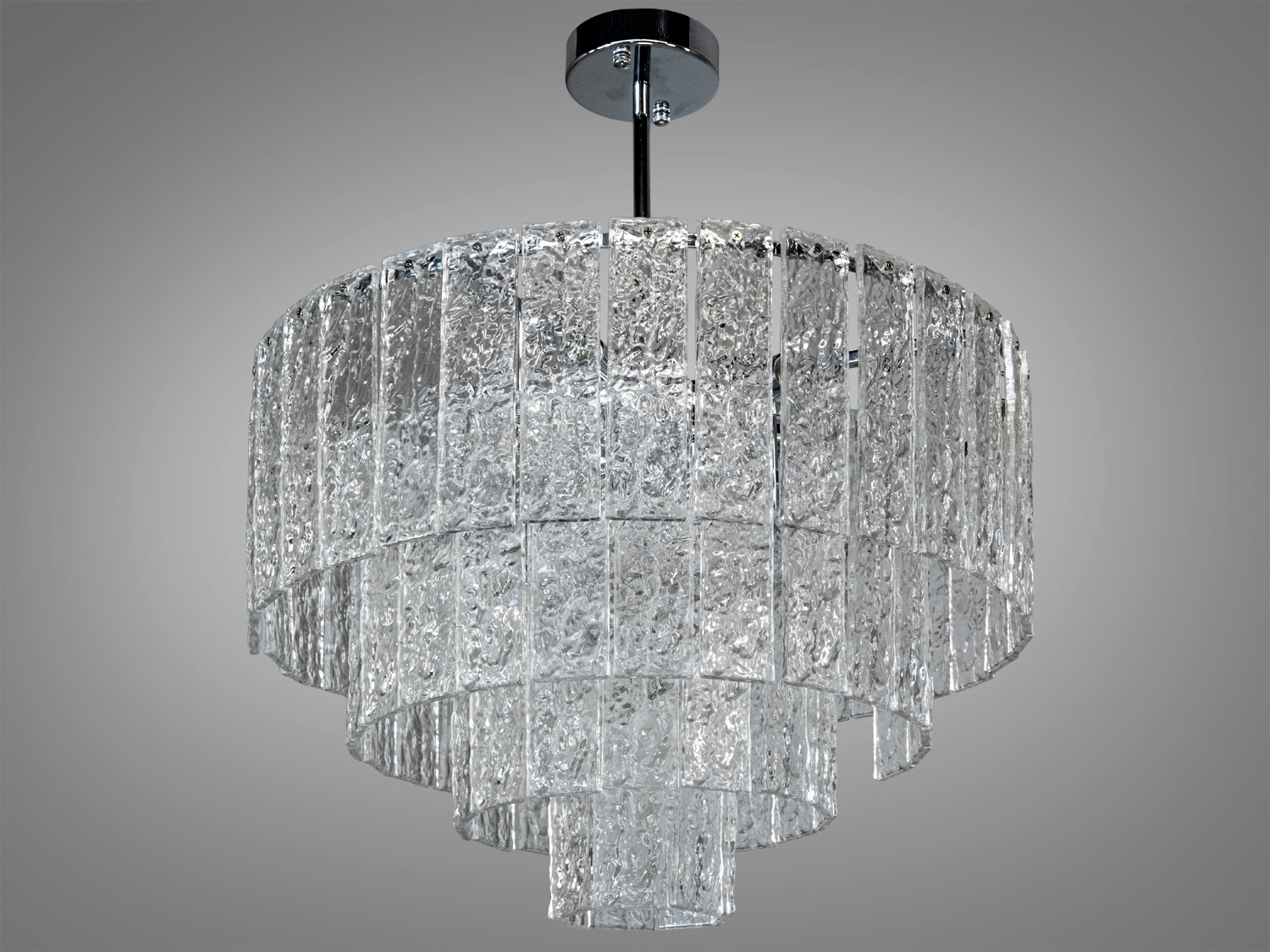 Каскадна люстра з прозорого скла з текстурованими елементами. Підходить для сучасного інтер′єру, забезпечуючи м′яке освітлення.