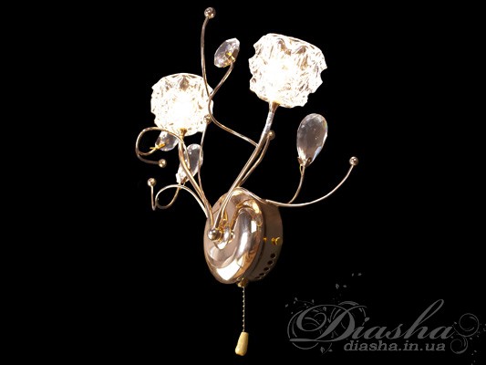 Світильник з увімкненими лампами, що випромінюють м′яке світло через кришталеві абажури, підвішені на золотистій основі.
