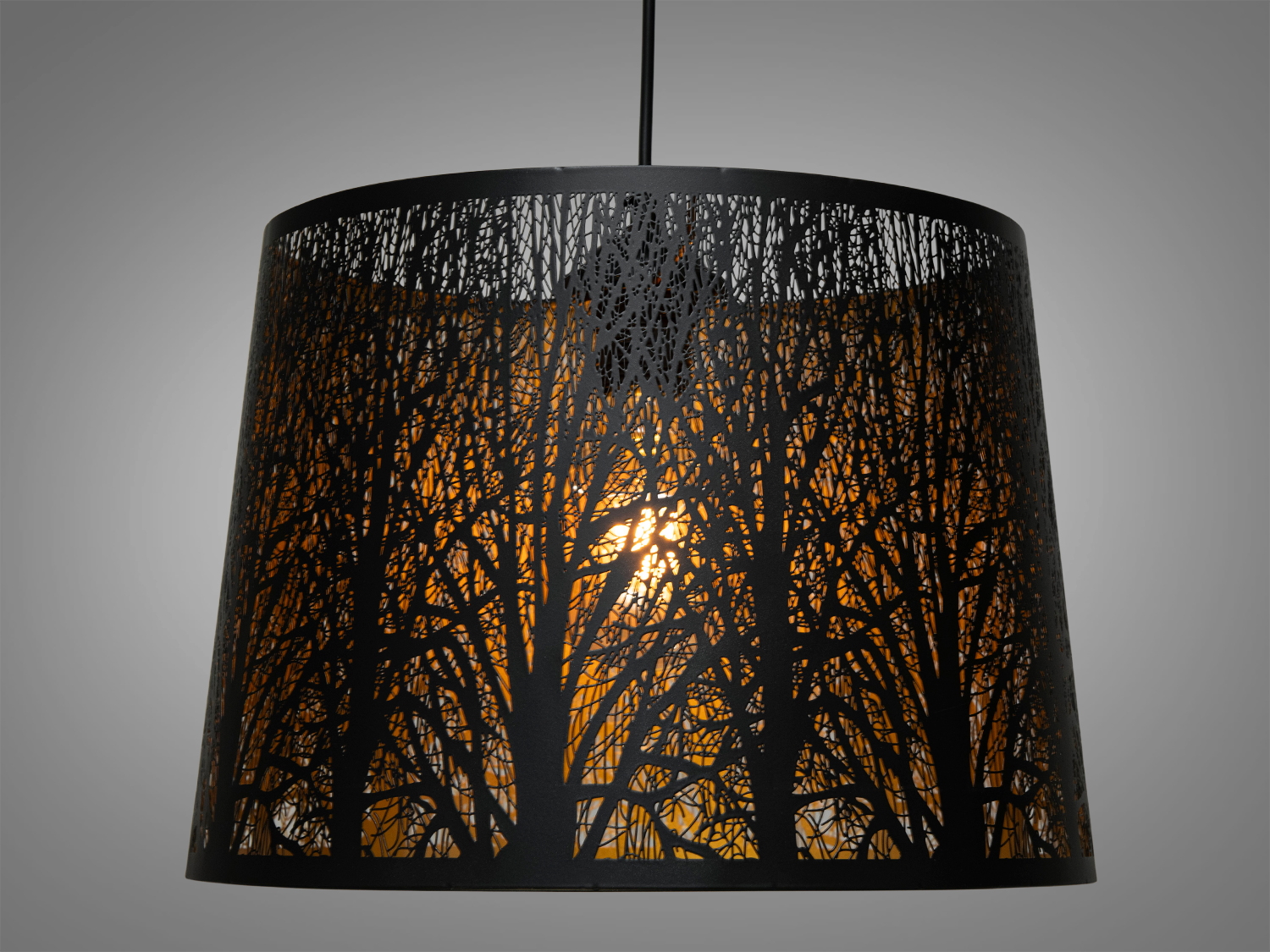 Підвісний світильник з металевим абажуром, що має вирізьблений візерунок дерев. Внутрішня частина створює тепле світло, ідеально для затишного інтер′єру.