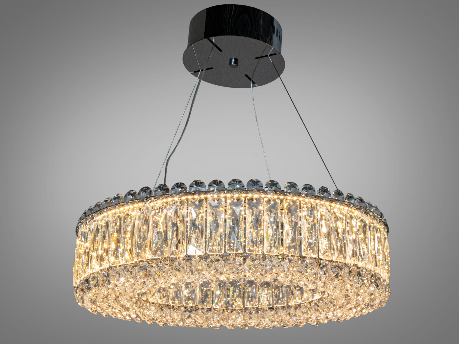 Сучасна кришталева люстра з кільцевими підвісками, що підвішена на тонких дротах. Підходить для високих стель.