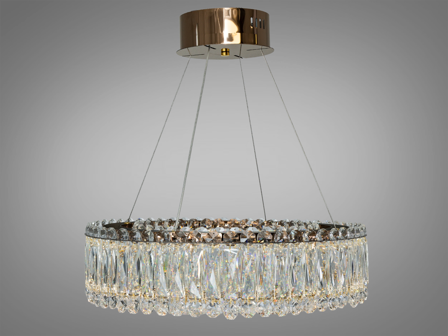 Кругла кришталева люстра з блискучими підвісками, що створює яскраве освітлення. Ідеально підходить для вітальні.