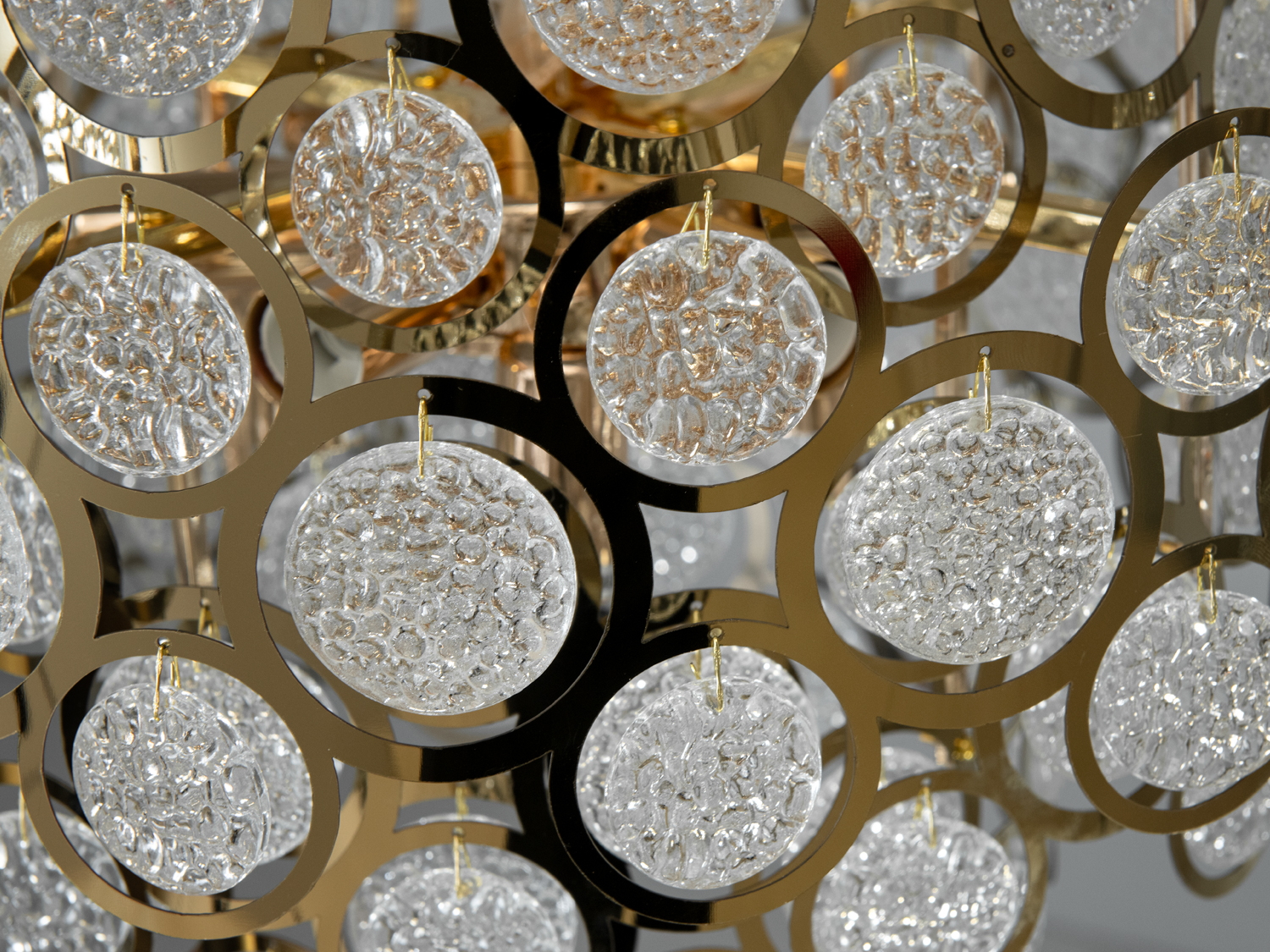 Скляні елементи люстри майстерно закріплені на золотистому каркасі, що робить люстру схожою на пишну корону або розкішний квітковий букет.