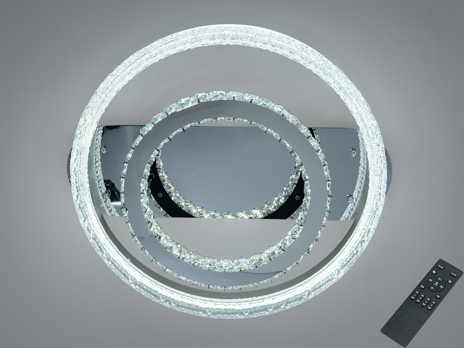 Стельовий світильник з двома кільцями із акрилу, менше з додаванням кришталів. Включає дистанційне керування для зручності.