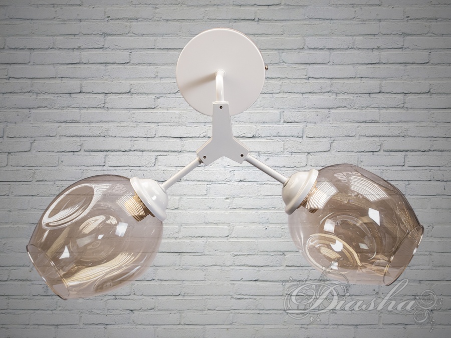 Наш настінний світильник є яскравим представником лофтового стилю, відомого своєю здатністю перетворити прості та суворі елементи промислового інтер'єру в естетично привабливі предмети домашнього затишку. Цей світильник має лаконічну, але виразну конструкцію, що поєднує в собі функціональність та художню цінність, демонструючи простоту ліній та чистоту дизайну.
Основа світильника виготовлена з металу, покритого білою фарбою, що надає йому сучасного вигляду та легкості. Від основи відходять два плафони, виконані з прозорого скла з оригінальними візерунками, які ловлять та відбивають світло, створюючи неповторну гру світлотіні в просторі. Форма плафонів органічно поєднується з загальною концепцією світильника, додаючи загальному вигляду легкості та повітряності.
Під лампу Е27, яка є стандартом для багатьох домашніх освітлювальних приладів, цей світильник забезпечує достатнє освітлення для різних житлових просторів. Він може використовуватися як у вітальні, так і в інших кімнатах, де потрібно створити виразний акцент або додати простору візуальної просторовості.
Настінний світильник в стилі лофт може бути ідеальним вибором для тих, хто шукає елемент декору, який би втілював індустріальний дух і сучасну елегантність. Його простий, але графічний дизайн робить його відмінним доповненням до інтер'єру, надаючи йому витонченого характеру та створюючи атмосферу, в якій кожна деталь має своє значення.
Скляні плафони світильника не просто розсіюють світло, але й перетворюють його, надаючи освітленню м'якості та теплоти. Вони ніби застиглі бульбашки шампанського, які захоплюють своєю грацією та здатністю перетворювати просте світло в невловимий візерунок на стінах і стелі.
Цей настінний світильник – це не просто практичний прилад, але й витвір мистецтва, здатний додати будь-якому простору відчуття стилю та унікальності. Він втілює дух лофту, де кожен предмет має свою історію, кожен куток зберігає свої секрети, а кожен промінь світла розповідає свою історію.
Лампи в комплект не входять.