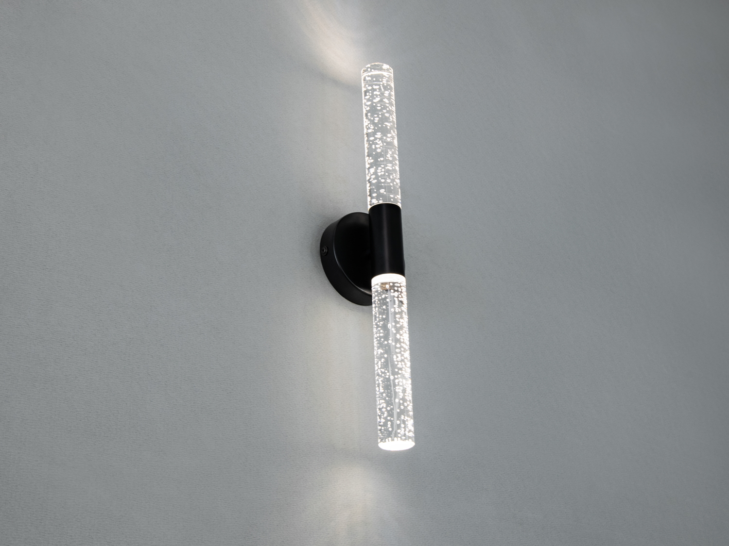 Декоративний світильник з чорним кріпленням, вертикальна орієнтація, створює атмосферне освітлення, підходить для спальні.