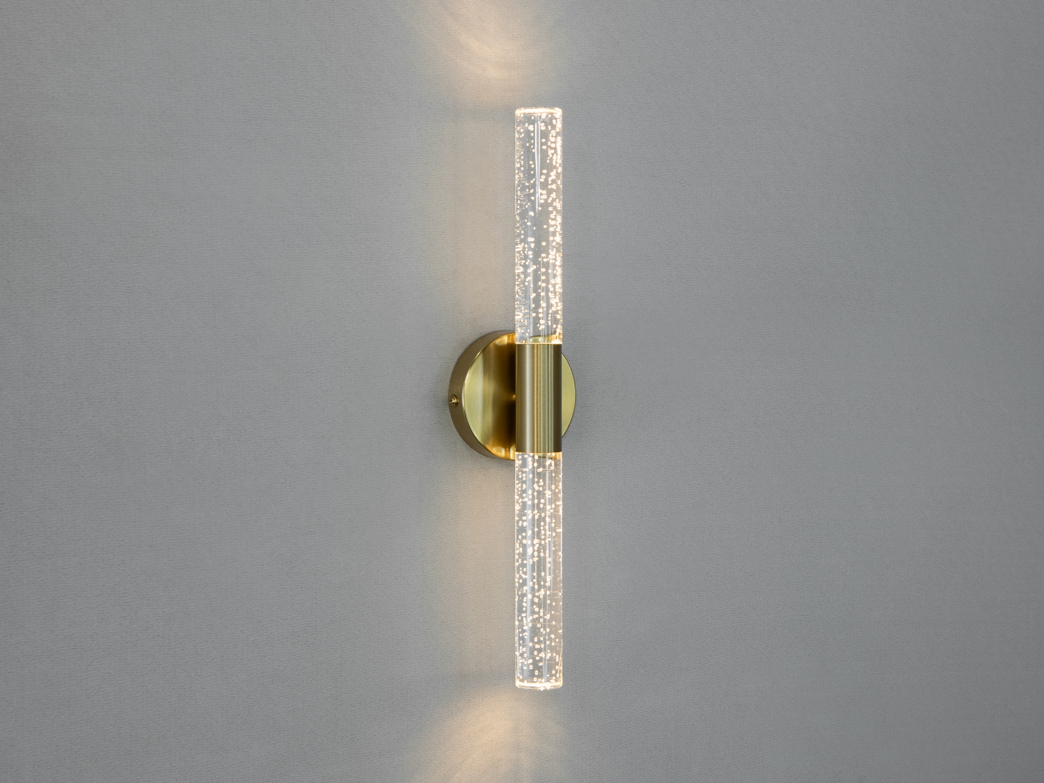{EN:Wall lamp with transparent tubes and a golden base. Suitable for modern interiors, it provides soft, diffused lighting.}
