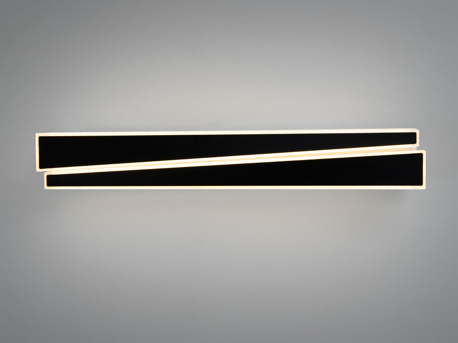 Лампа з паралельними чорними панелями, що світяться теплим світлом. Підходить для монтажу на стіну в сучасних приміщеннях.