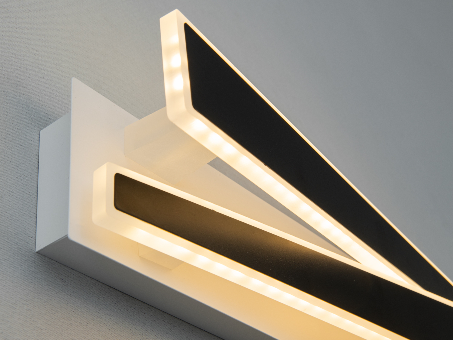 Чорні акрилові панелі світильника з теплим жовтим підсвічуванням, що підходять для спальні. Монтаж на стіну.