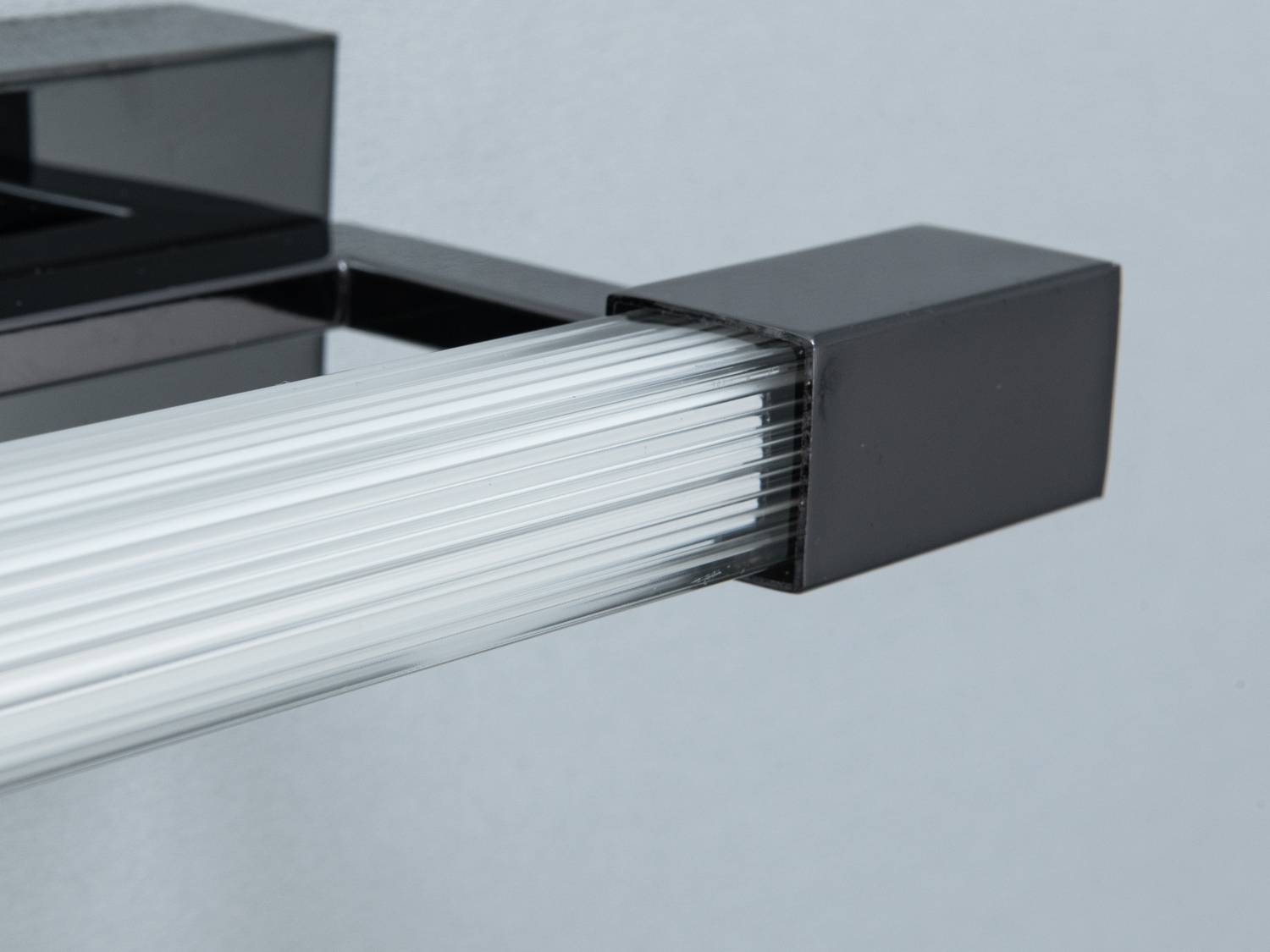 Крупний план акрилового світлодіодного елемента в чорному корпусі, що підкреслює його текстуровану поверхню та стильний дизайн.