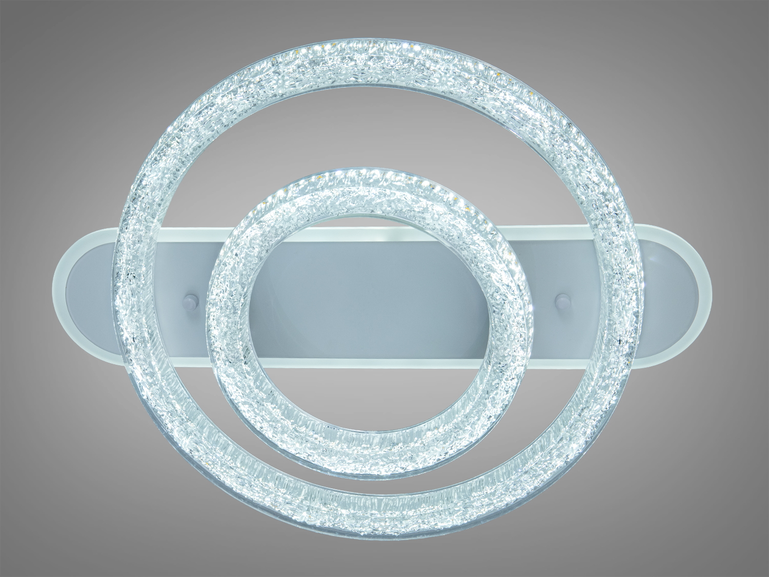 Стельова люстра з двома прозорими кільцями, які створюють м′яке біле світло, підходить для монтажу у вітальні.