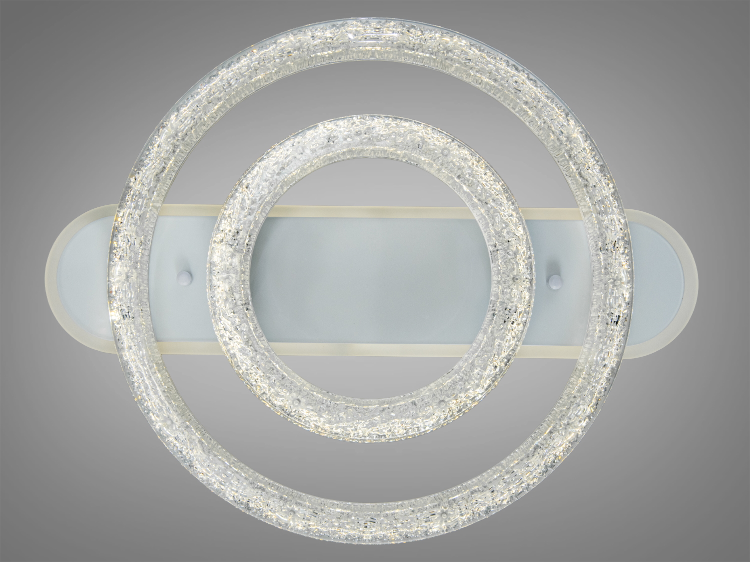 Люстра з двома кільцями, що випромінюють тепле світло, ідеально підходить для спальні, має стильний дизайн.