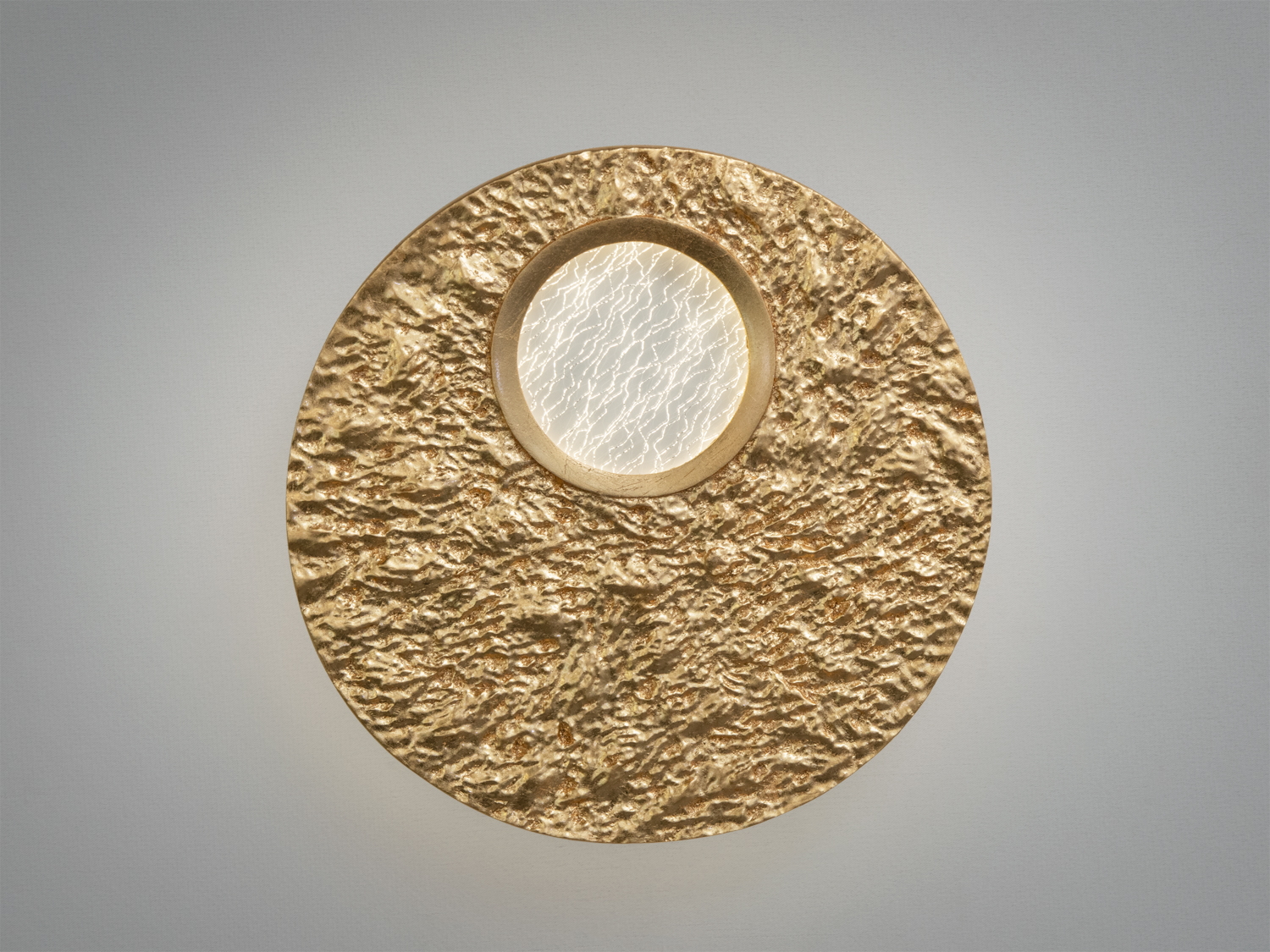Круглий настінний світильник з текстурованою золотою акриловою поверхнею та центральним прозорим елементом. Ідеальний для акцентного освітлення.