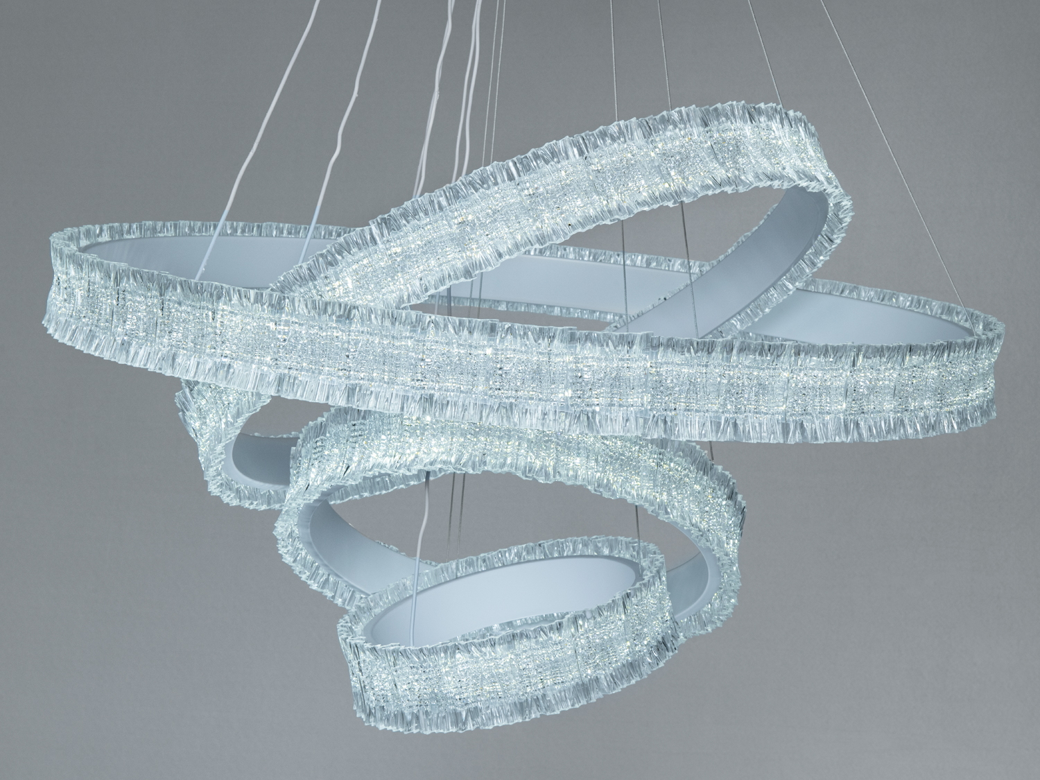 Кришталевий світильник з теплим білим світлом, що надає затишку. Підвісні кільця мають текстуровану поверхню.