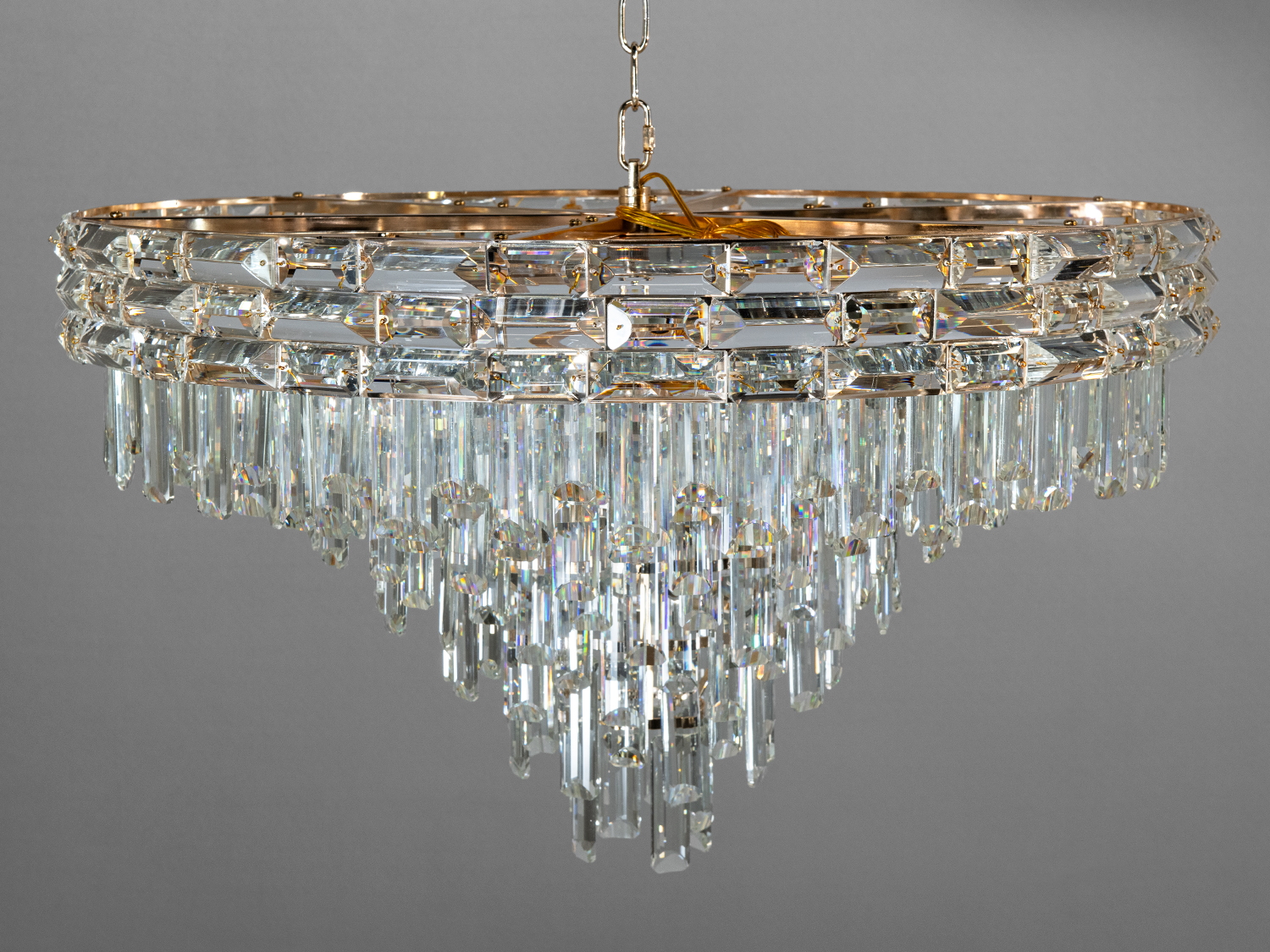 Кругла кришталева люстра з підвісками, що створюють каскадний ефект. Ідеально підходить для вітальні з високою стелею.