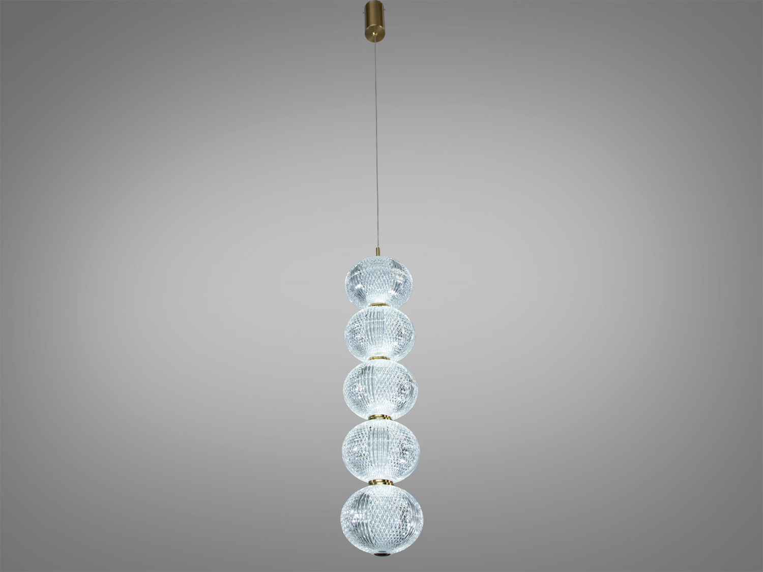 Підвісний світильник з п′яти скляних куль, підвішений на тонкому кабелі, ідеальний для високих стель.
