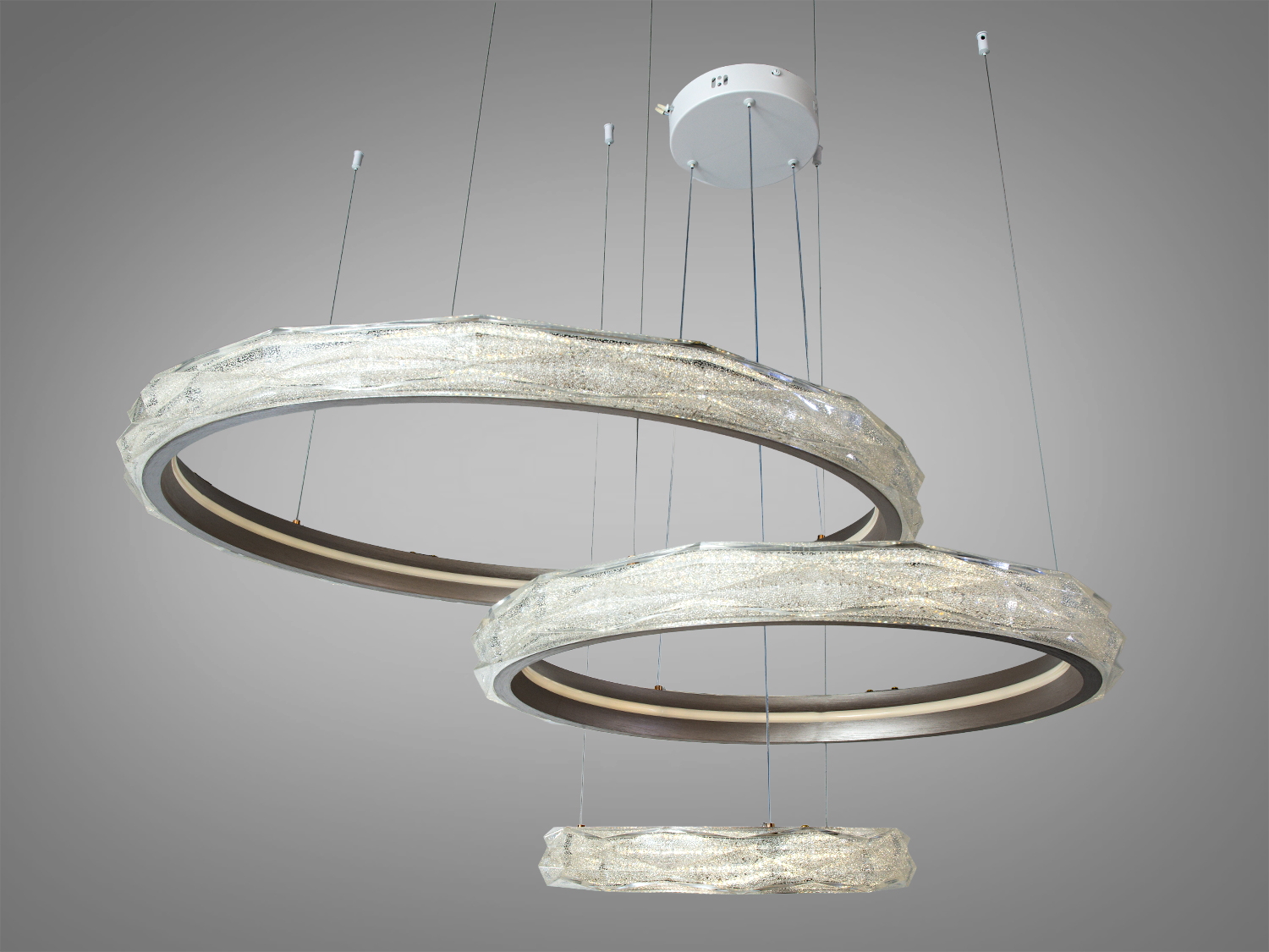 Три кільця люстри підвішені на регульованих тросах. Виготовлена з металу, підходить для високих стель у сучасних приміщеннях.