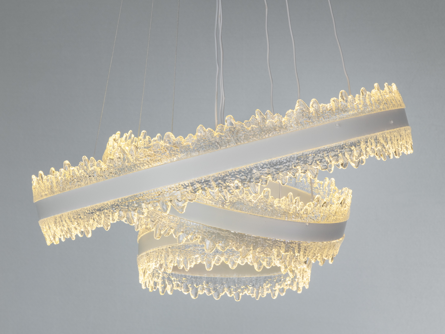 Кільця люстри мають текстуровану акрилову поверхню, що надає їм унікальний вигляд при ввімкненому теплому освітленні.