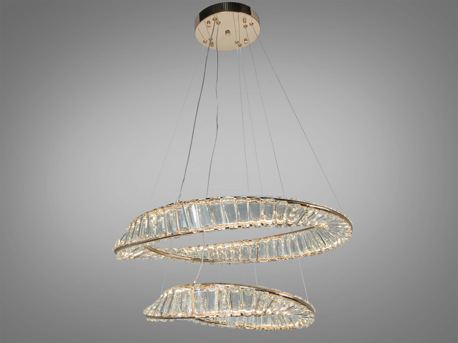 Люстра з двома кришталевими кільцями, підвішена на тонких тросах, створює ефект легкості в сучасному інтер′єрі.