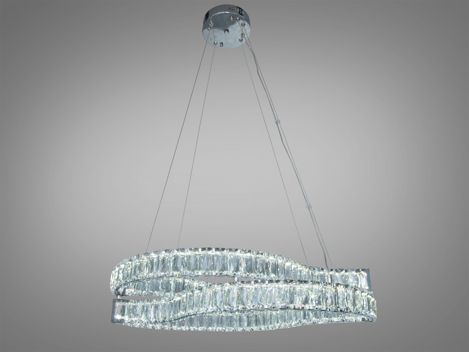 Підвісна люстра з хвилястим дизайном, виготовлена з прозорого кришталю, підвішена на круглій основі для стильного освітлення.
