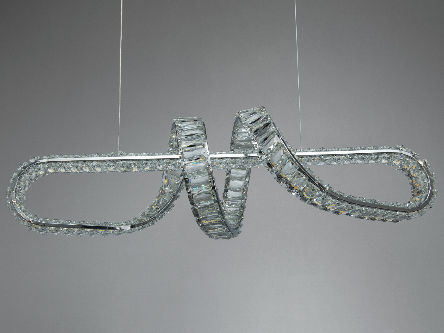 Близький план світильника у формі петлі з кристалами, що підвісний. Відбиває світло для створення ефекту блиску.