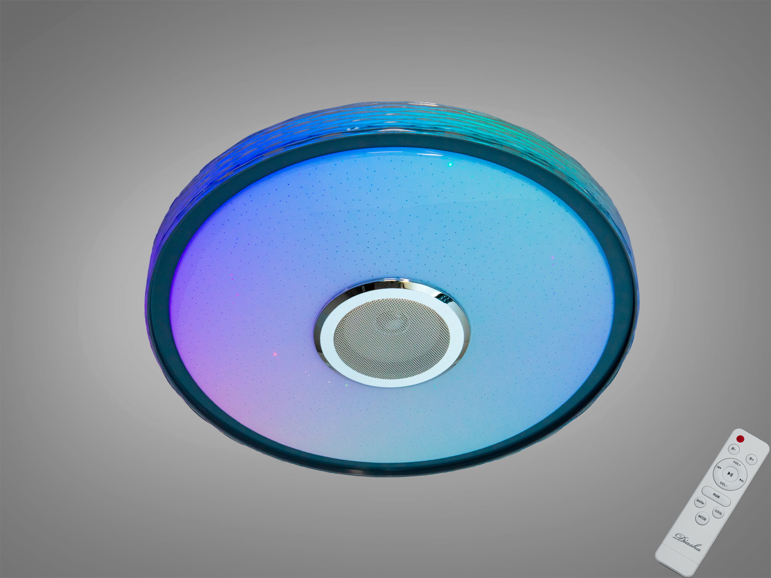 Кругла стельова лампа з кольоровим підсвічуванням, оснащена динаміком у центрі. Пульт дистанційного керування додає зручності.