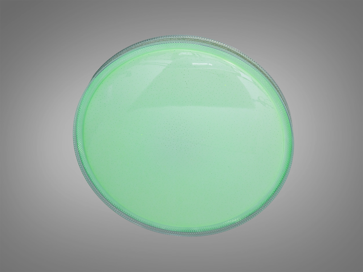 Кругла лампа з зеленим світлом, має гладку поверхню та підходить для встановлення в житлових приміщеннях.