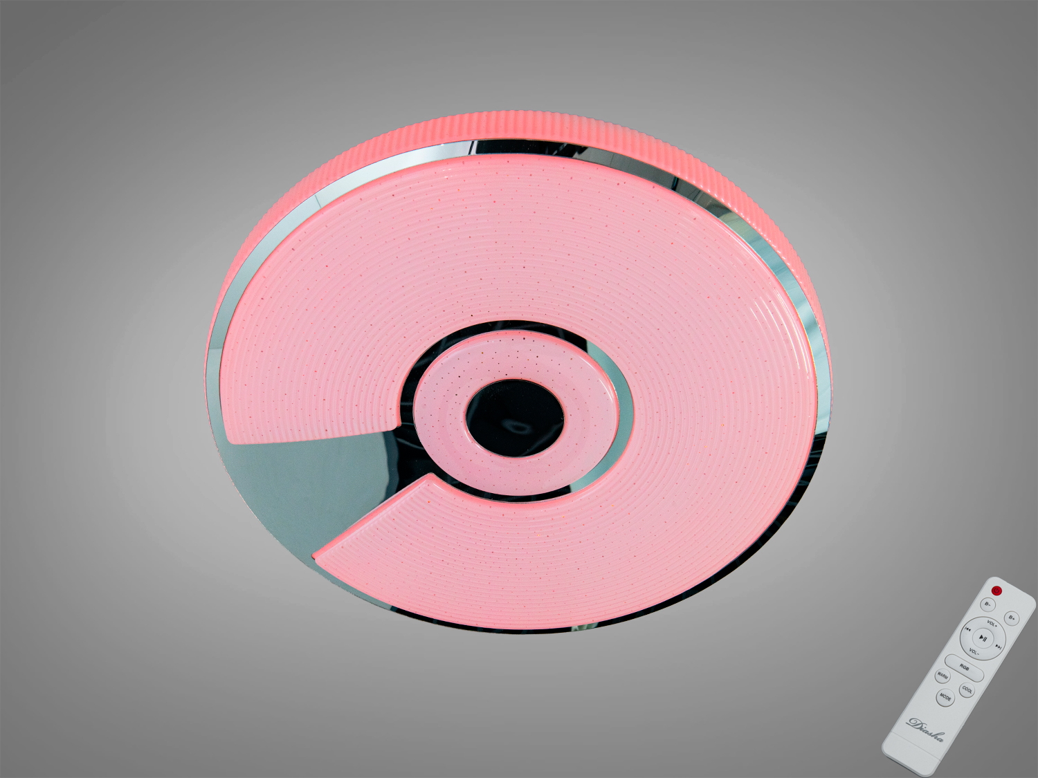 Кругла стельова лампа з рожевим світлом та сріблястими вставками, оснащена пультом дистанційного керування для зручного регулювання освітлення.