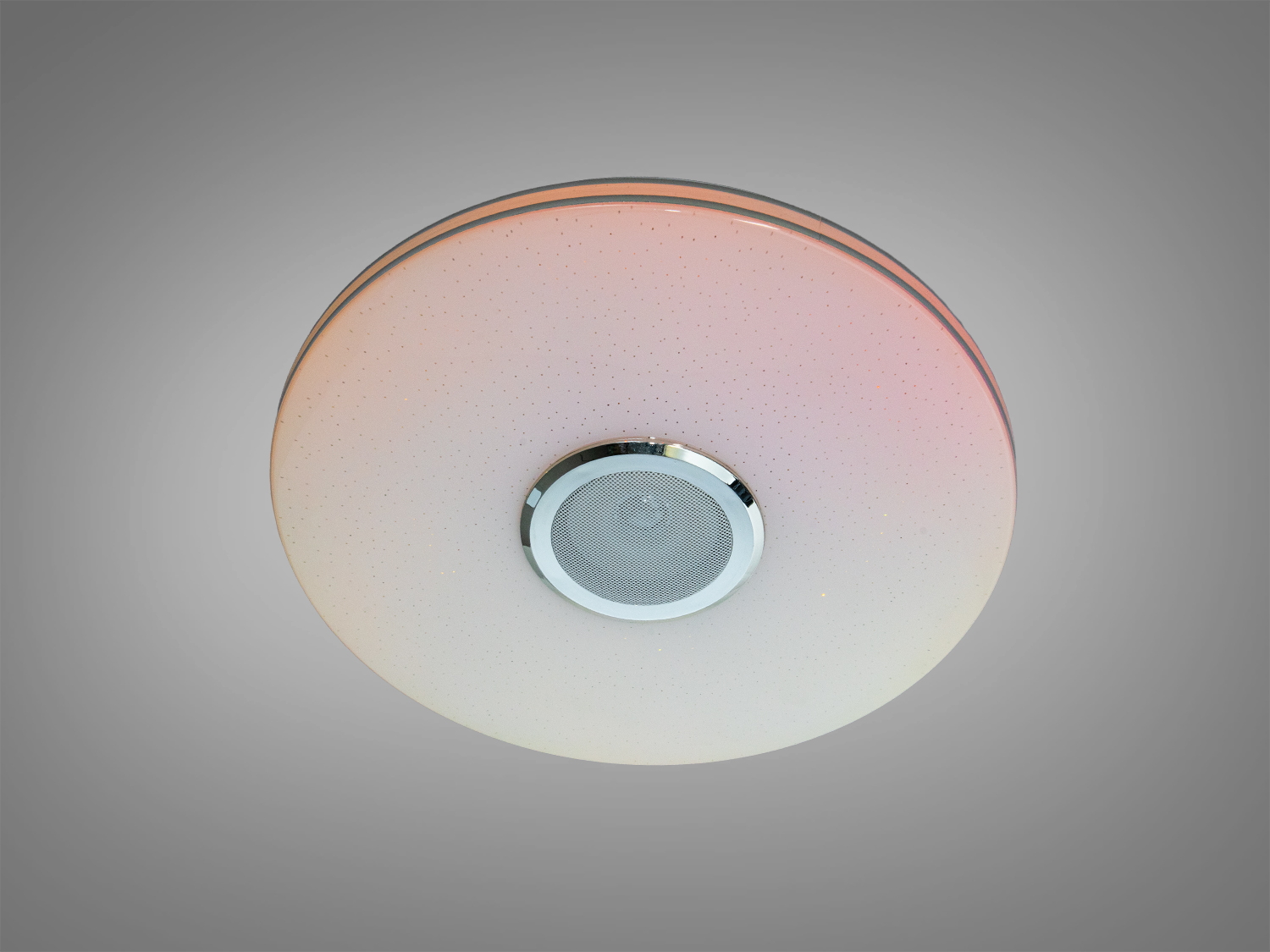 Круглий стельовий світильник з теплим рожевим відтінком, підходить для спальні. Має вбудовану акустику для створення затишної атмосфери.
