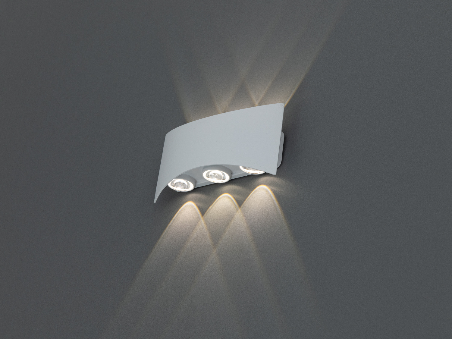 Білий настінний світильник з трьома лампами, спрямованими вниз, забезпечує акцентне освітлення в сучасному інтер′єрі.