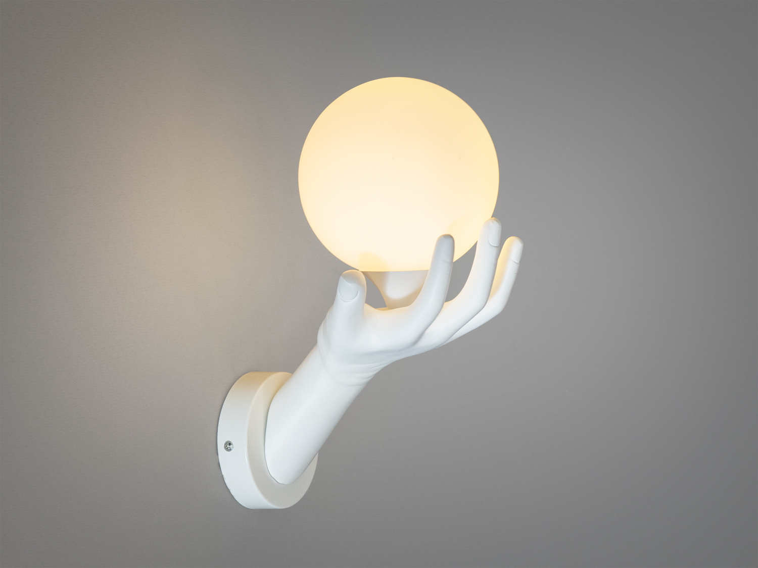 Настінний світильник у формі руки, що тримає круглий плафон. Ідеально підходить для сучасного інтер′єру, забезпечуючи м′яке освітлення.