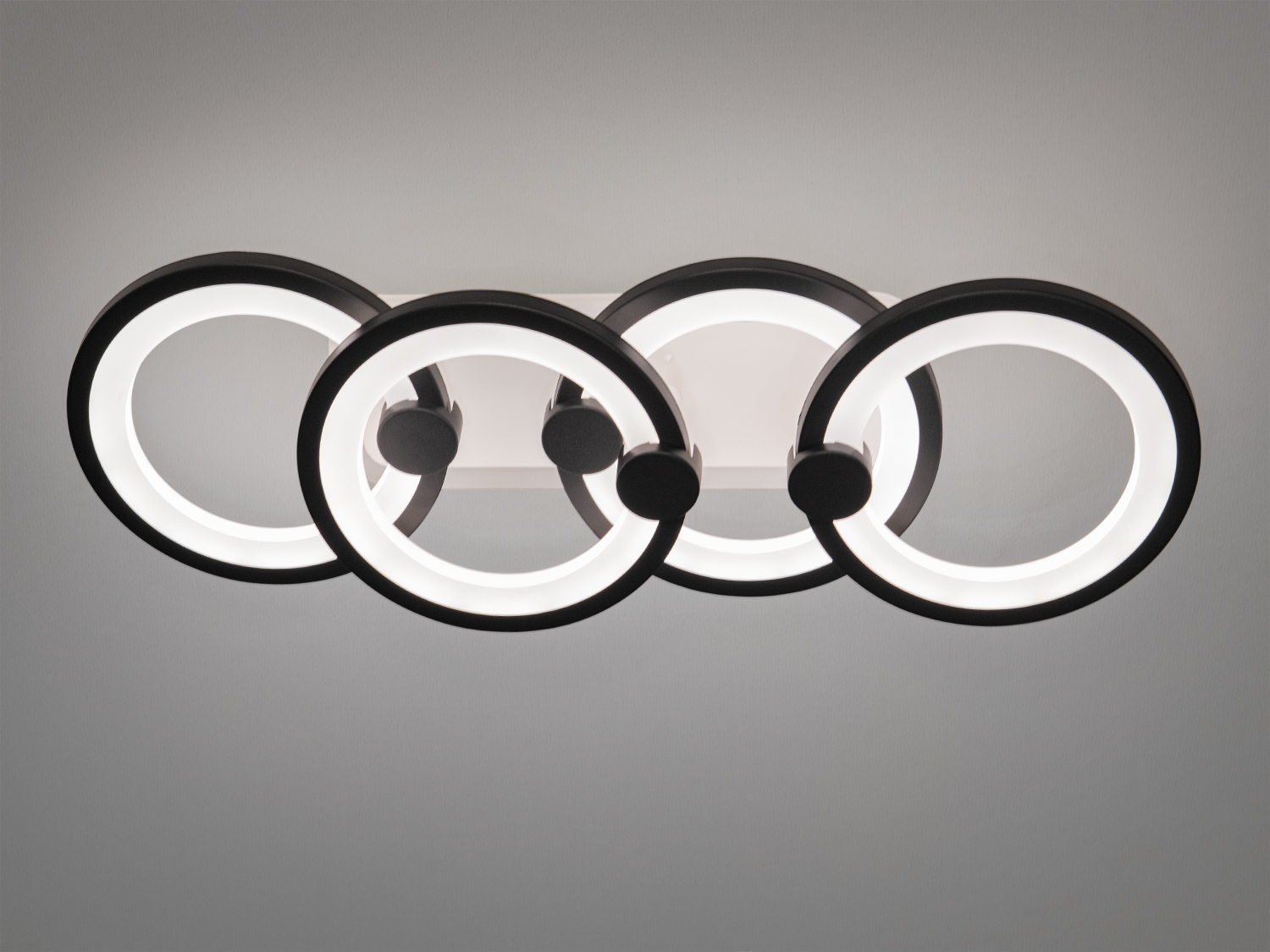 Настінний світильник з чотирма кільцями, що випромінюють яскраве біле світло. Ідеально підходить для освітлення робочих зон.