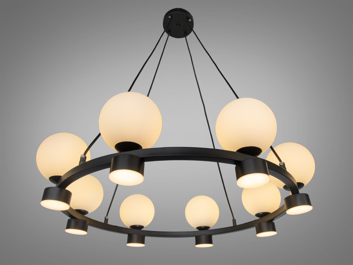 Підвісна люстра з матовими скляними кулями на чорному металевому каркасі. Підходить для сучасного інтер′єру.