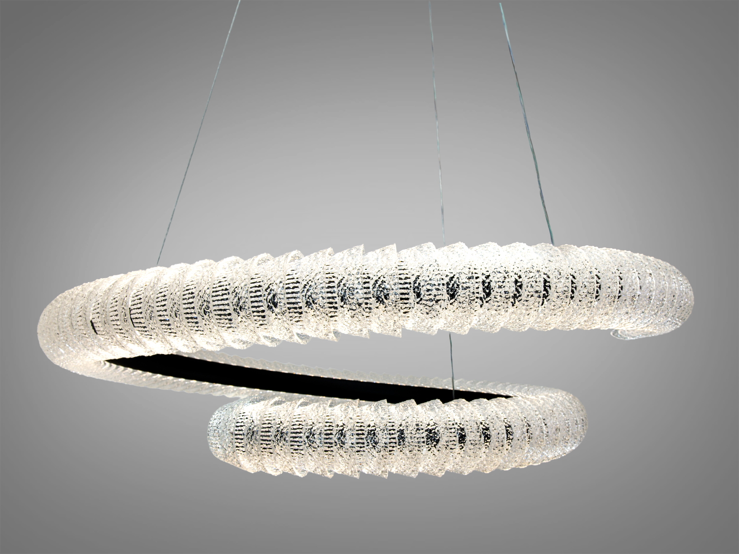 Підвісний світильник з подвійною спіраллю, виконаний з текстурованого акрилу, підходить для офісного простору.