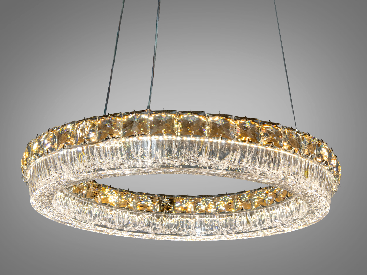 Кругла люстра з акриловими елементами, підвішена на тросах, створює ефектний акцент у вітальні.