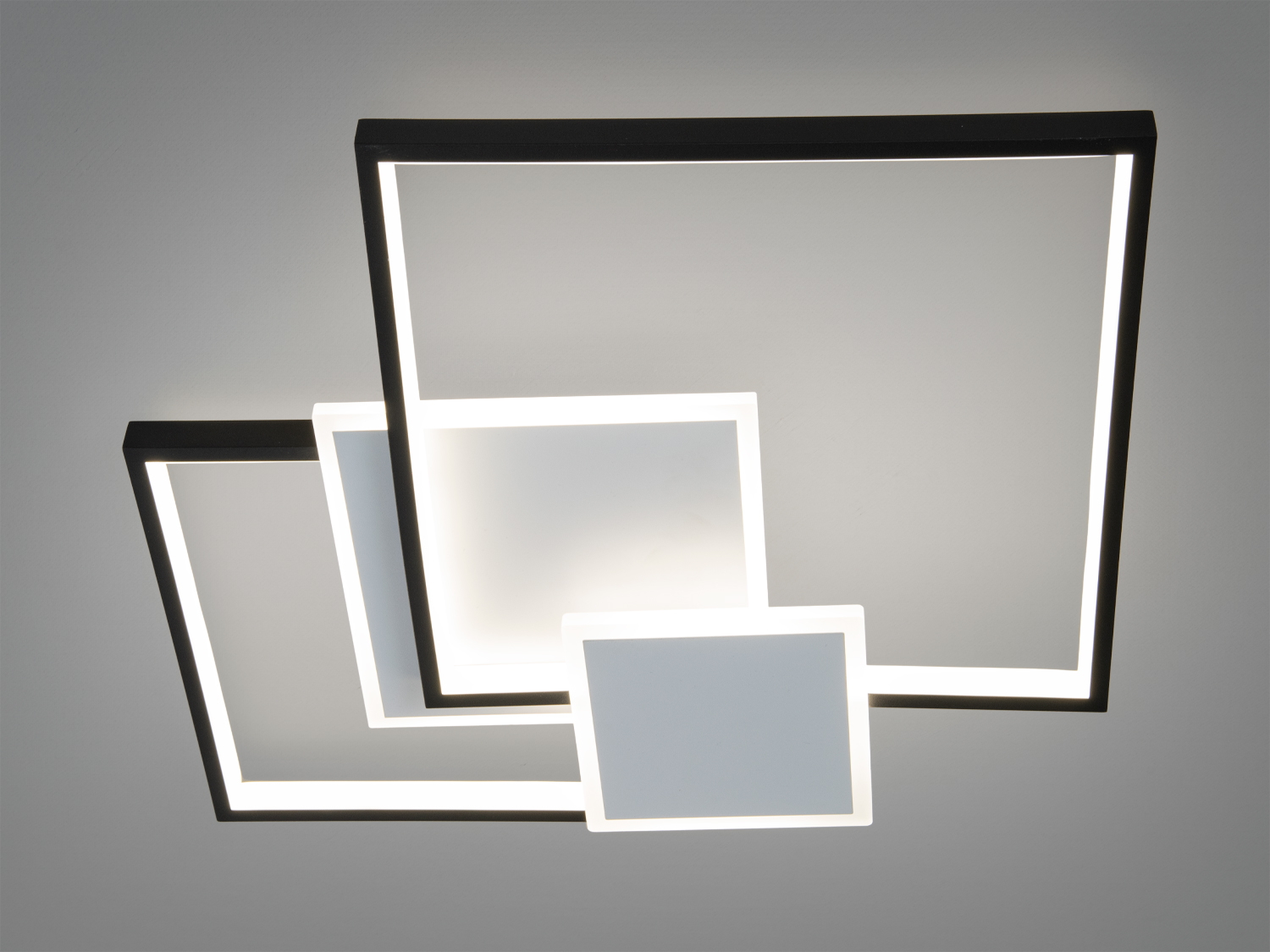 Стельовий світильник з трьома квадратними панелями різного розміру, з білими рамками. Ідеально підходить для офісних приміщень.