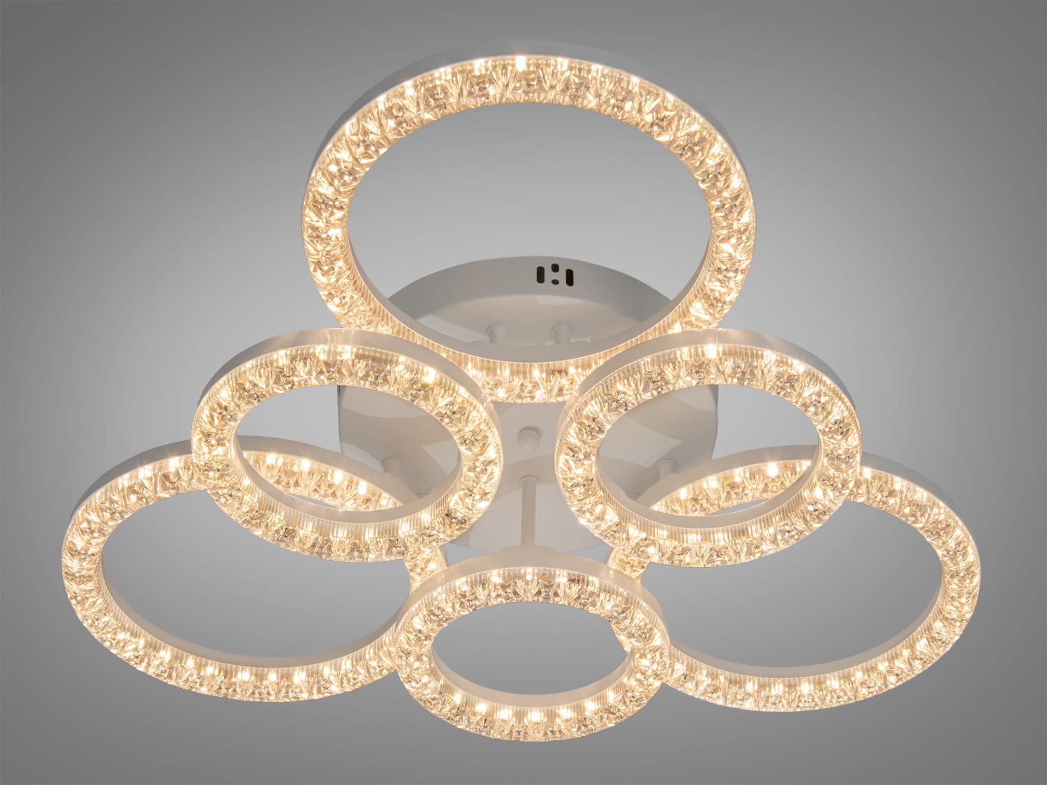 Лампа з шістьма кільцями, що випромінюють тепле жовте світло, підходить для затишної вітальні.