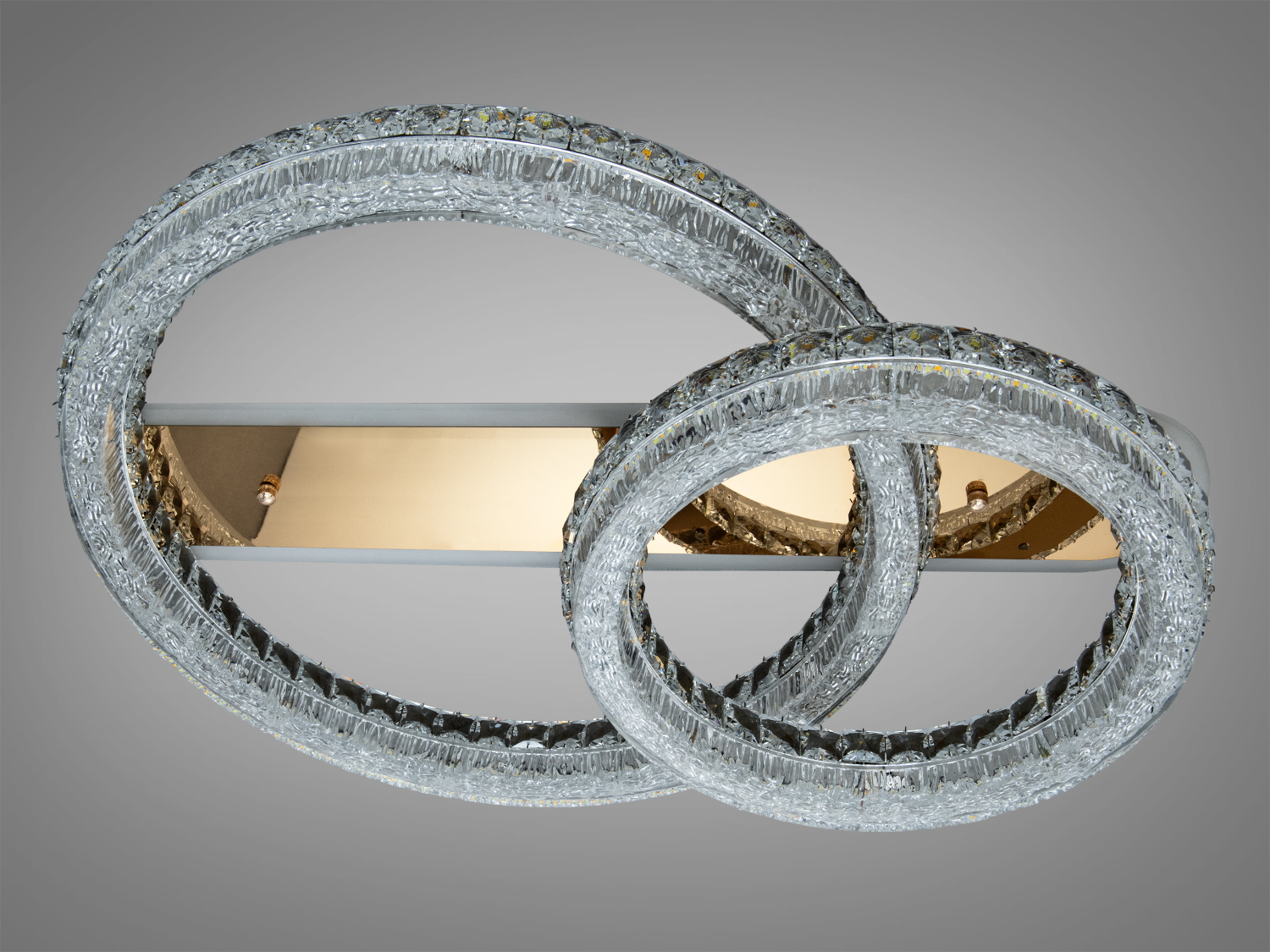 Світильник з двома кільцями, що перетинаються, на золотистій основі. Ідеальний для стельового монтажу у вітальні.