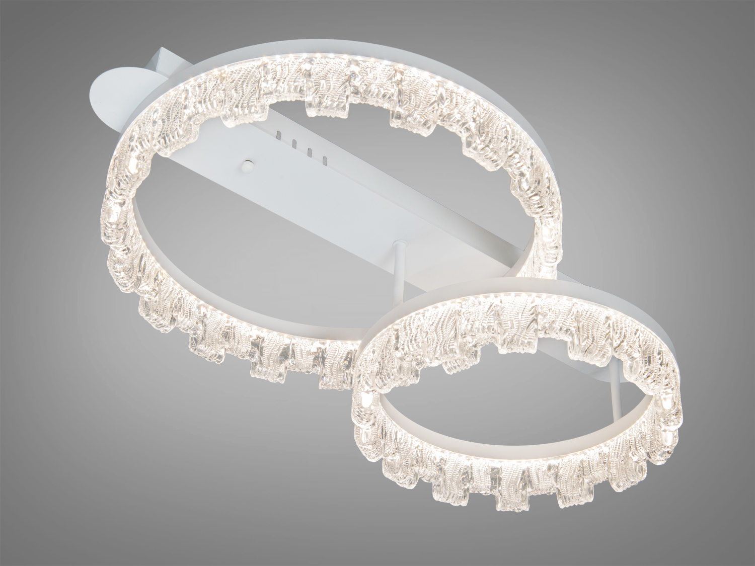 Декоративний світильник з двома кільцями, що створюють м’яке біле світло. Підходить для стельового монтажу, виготовлений з прозорого матеріалу.