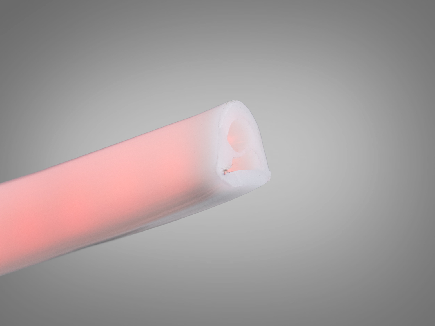 Кінець рожевої світлодіодної стрічки з гладкою поверхнею, демонструє перетин матеріалу, підходить для різних дизайнерських рішень.