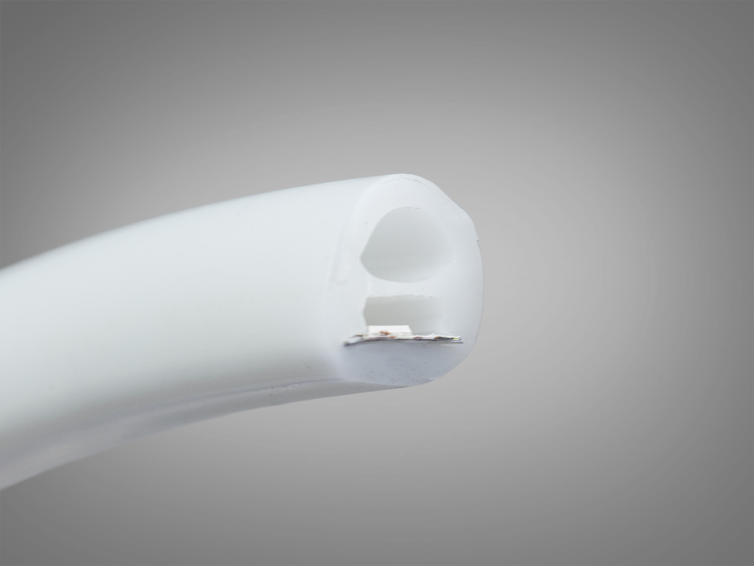 Кінець світлодіодної стрічки з видимою внутрішньою структурою, виготовлений з міцного матеріалу, підходить для різних монтажних рішень.