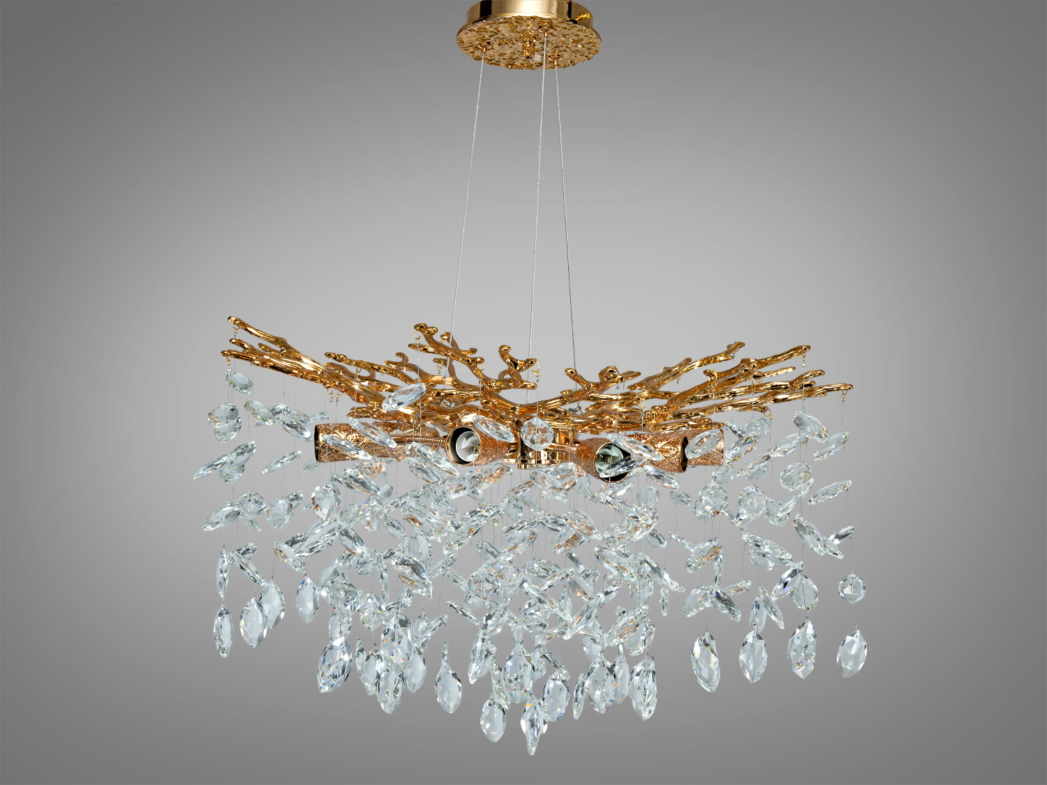 Підвісна люстра з кришталевими підвісками, що нагадують краплі води, підвішена на золотистій основі з гілками.