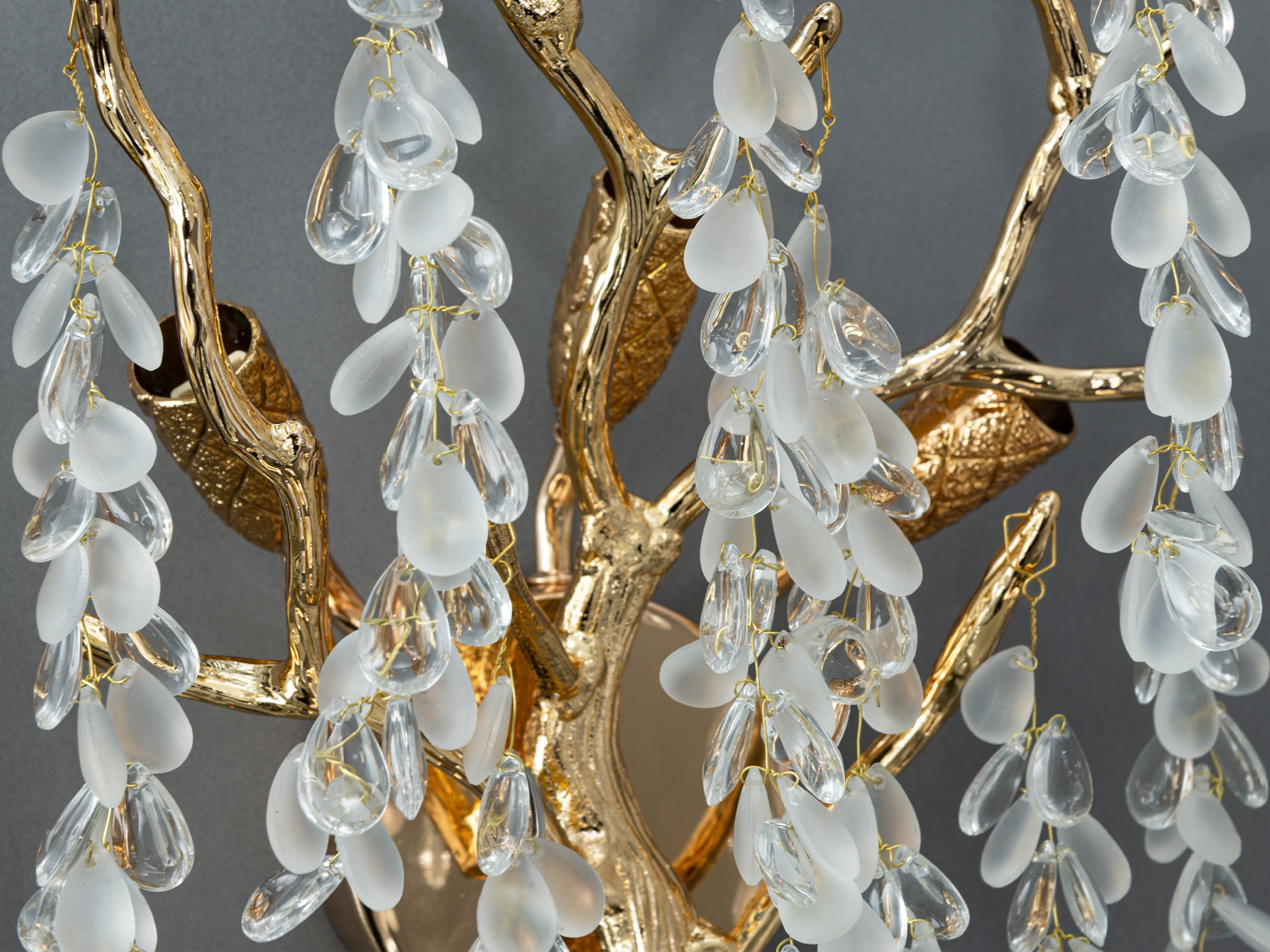Детальний вигляд світильника з матовими та прозорими кришталевими підвісками на золотих гілках, підкреслює витонченість дизайну.