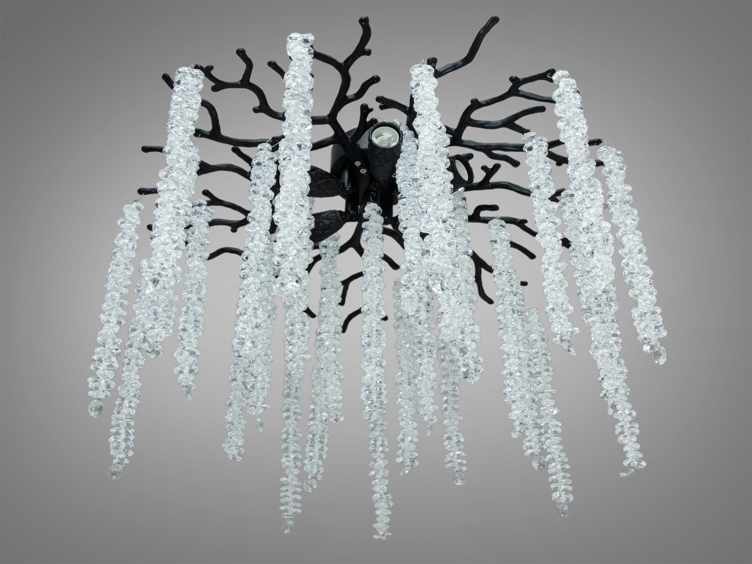 Дизайн люстри з чорними гілками та прозорими підвісками підходить для акцентного освітлення вітальні або спальні.